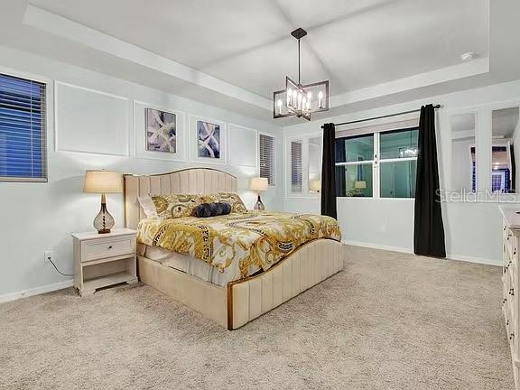 1919 Tropical Palms Circle Kissimmee, FL 34747 - Photo 11 of 41 a spacious bedroom with a large bed and a chandelier