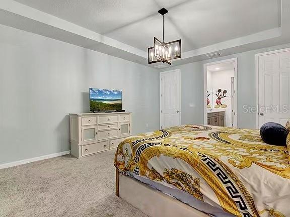 1919 Tropical Palms Circle Kissimmee, FL 34747 - Photo 12 of 41 a bedroom with a bed and a chandelier