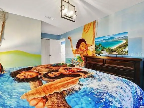 a bedroom with a bed and a lamp on dresser