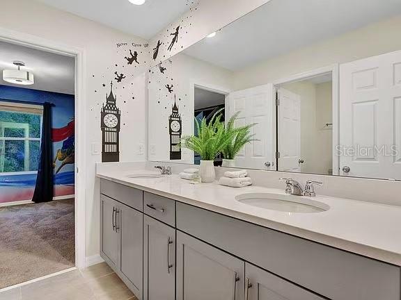 1919 Tropical Palms Circle Kissimmee, FL 34747 - Photo 20 of 41 a bathroom with double vanity sinks a vanity a lamp and a mirror