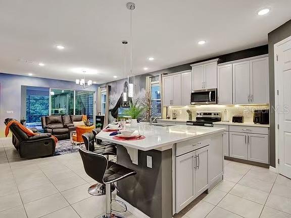 1919 Tropical Palms Circle Kissimmee, FL 34747 - Photo 3 of 41 a kitchen with stainless steel appliances kitchen island granite countertop a sink dishwasher a stove a microwave oven and white cabinets with wooden floor