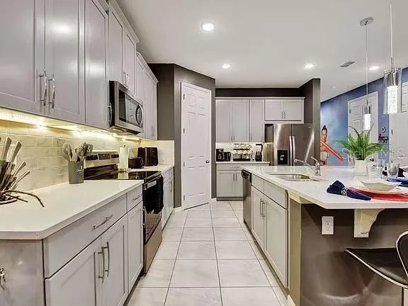 a living room with furniture kitchen view and a chandelier