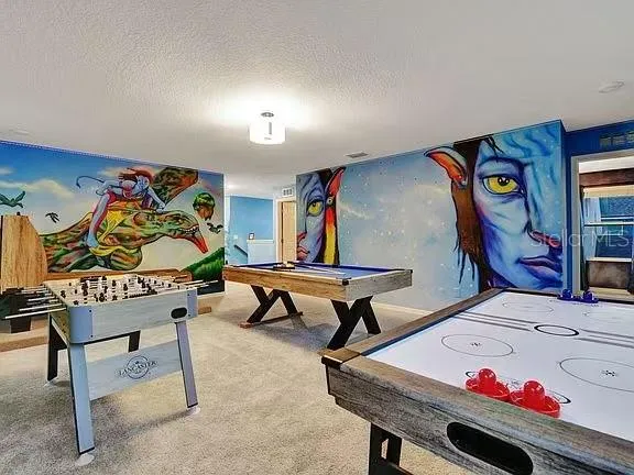 an aerial view of a house with swimming pool and outdoor seating