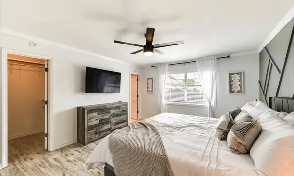 a bedroom with a bed and wooden floor