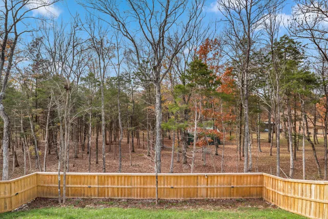 a view of a patio with table and chairs with wooden floor and fence