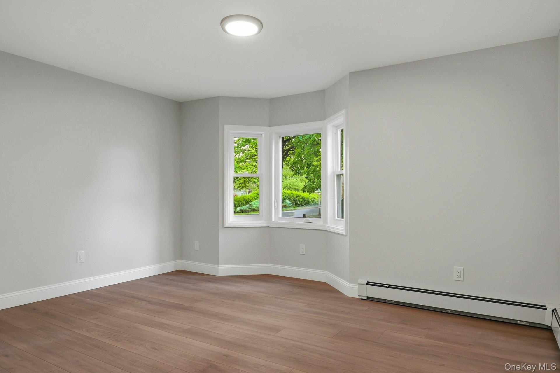 101 Rustic Road Centereach, NY 11720 - Photo 27 of 42 an empty room with wooden floor and windows