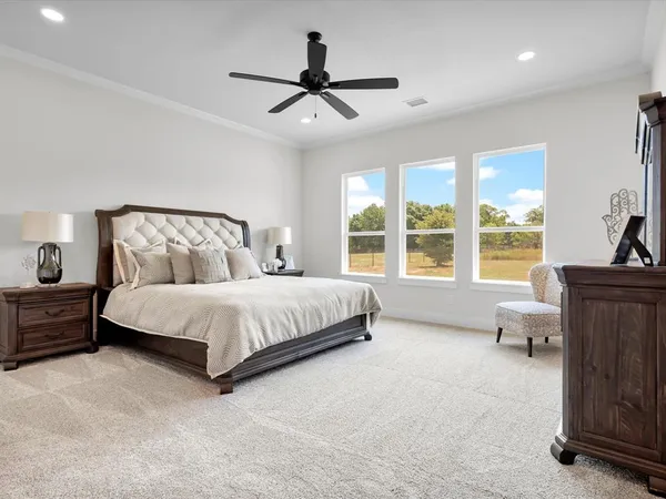 a bed sitting in a spacious bedroom next to a window