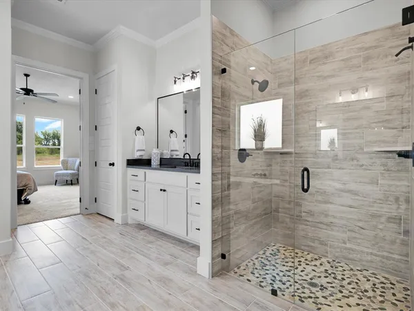 a bathroom with a double vanity sink a large mirror and shower