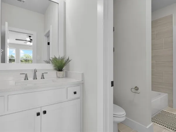a bathroom with a granite countertop sink mirror vanity and toilet