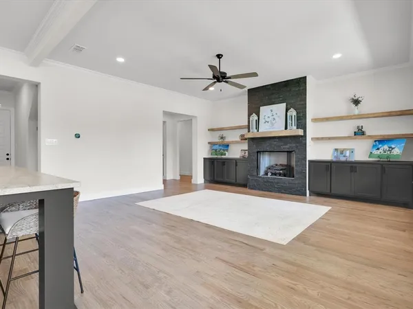 a living room with furniture a fireplace and a ceiling fan