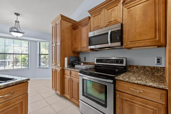 a kitchen with stainless steel appliances granite countertop a stove microwave and cabinets