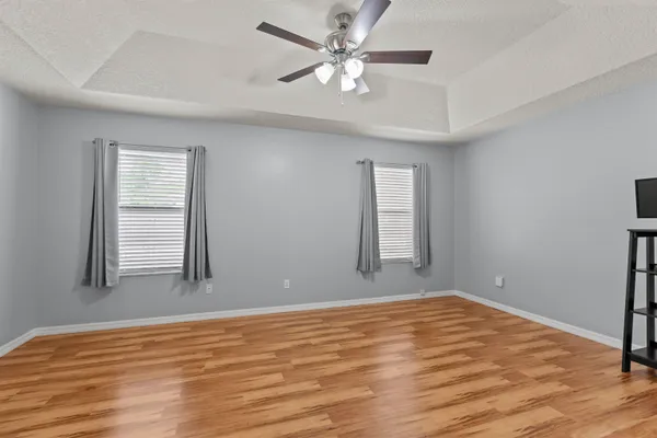 a view of an empty room with window and wooden floor