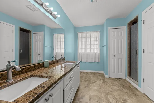 a bathroom with sinks granite countertop double vanity and a mirror