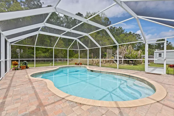 a view of a swimming pool with a chair in the balcony