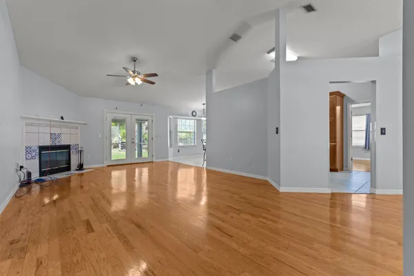 a view of empty room with wooden floor and fireplace