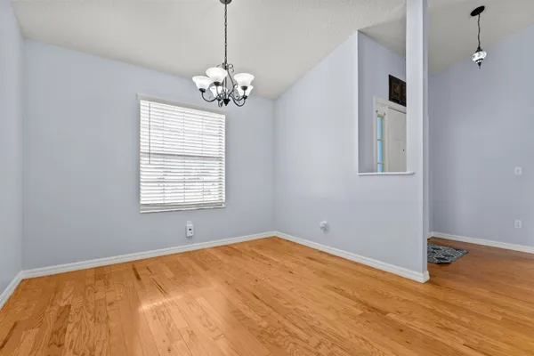 a view of a room with wooden floor and chandelier