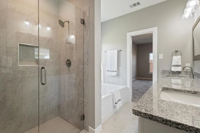 a bathroom with a granite countertop sink a mirror and shower
