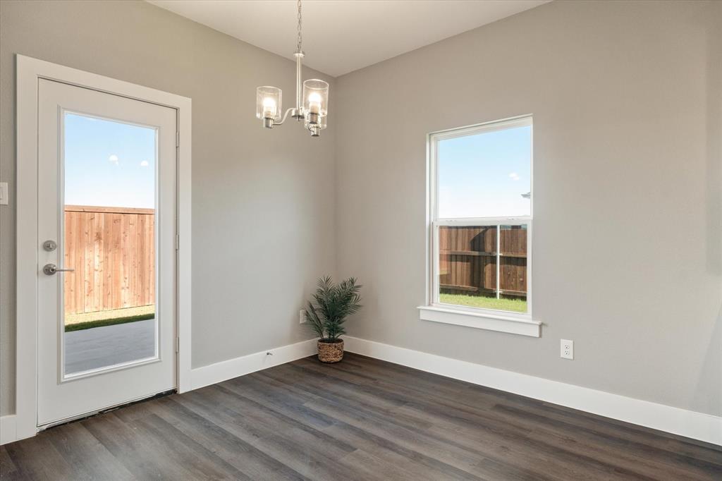 434 Cirrus Circle Muenster, TX 76252 - Photo 8 of 29 an empty room with wooden floor chandelier and windows