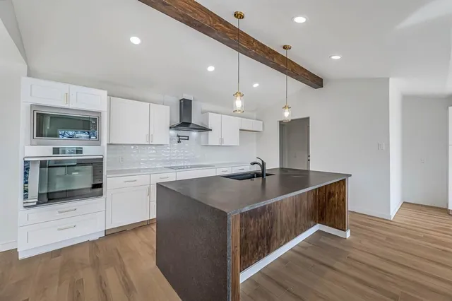 a kitchen with kitchen island a sink stainless steel appliances and cabinets