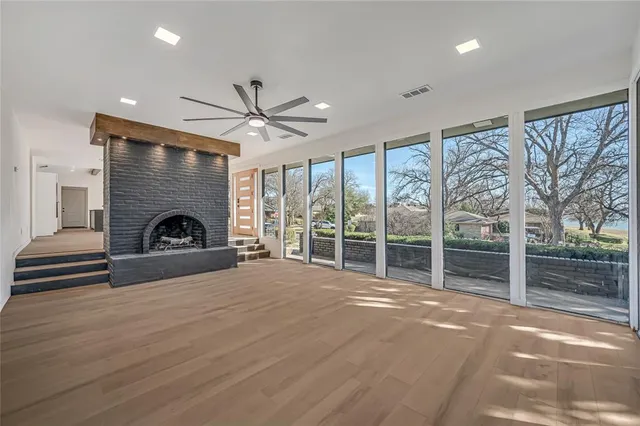 a view of an empty room with a fireplace and a large window