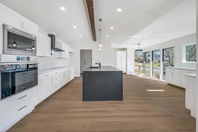 a large kitchen with stainless steel appliances granite countertop a large counter top and a stove