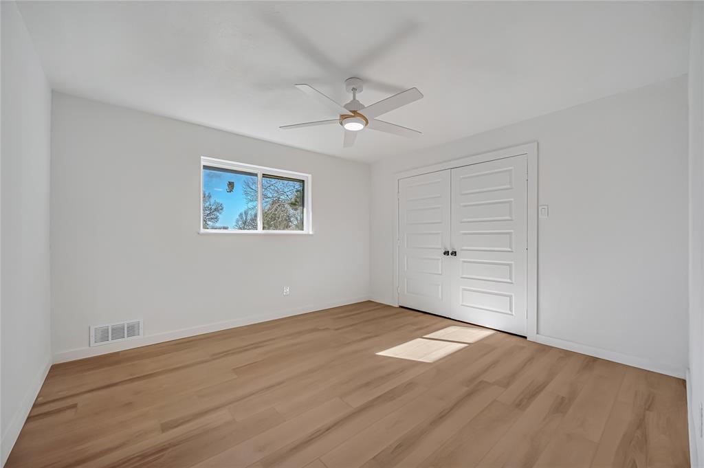 109 Pecan Drive Rowlett, TX 75087 - Photo 29 of 39 an empty room with wooden floor ceiling fan and windows