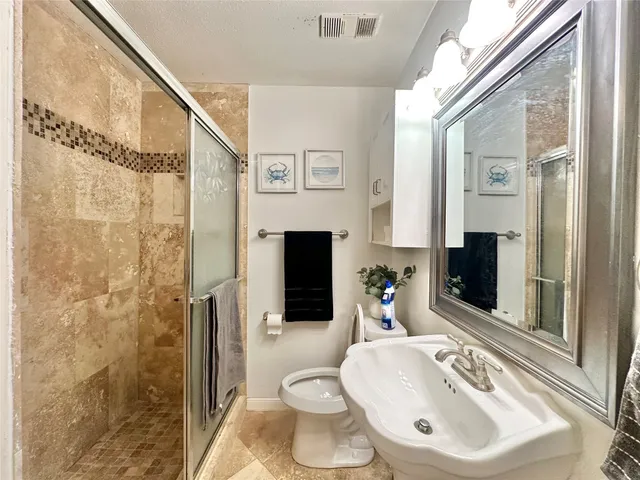 a bathroom with a sink toilet and shower