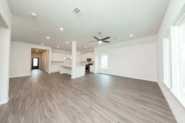 a view of empty room with wooden floor