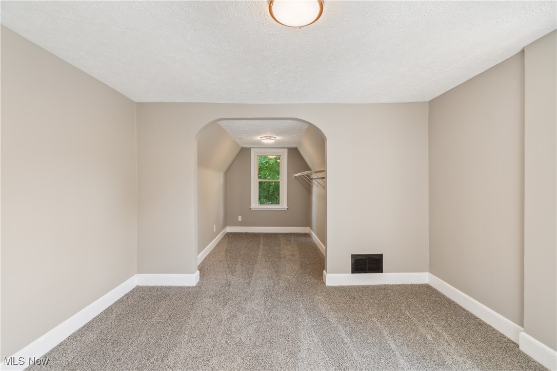 451 West Waterloo Road Akron, OH 44314 - Photo 16 of 27 Empty room with vaulted ceiling, a textured ceiling, and carpet flooring