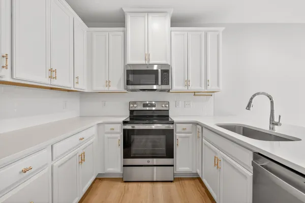 a kitchen with white cabinets and stainless steel appliances