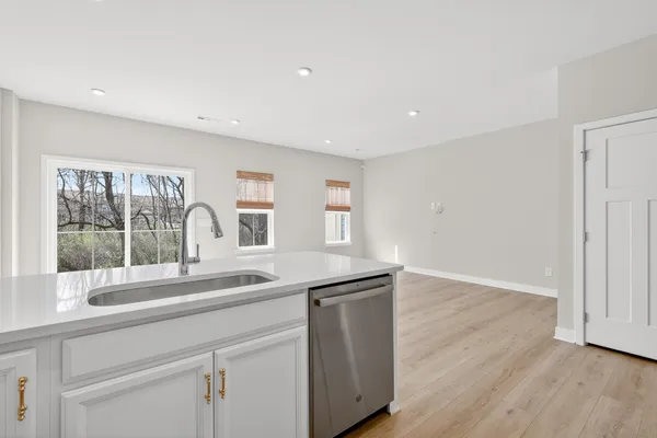 a kitchen with granite countertop a sink and dishwasher with wooden floor