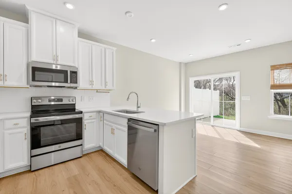 a kitchen with stainless steel appliances a stove sink and microwave