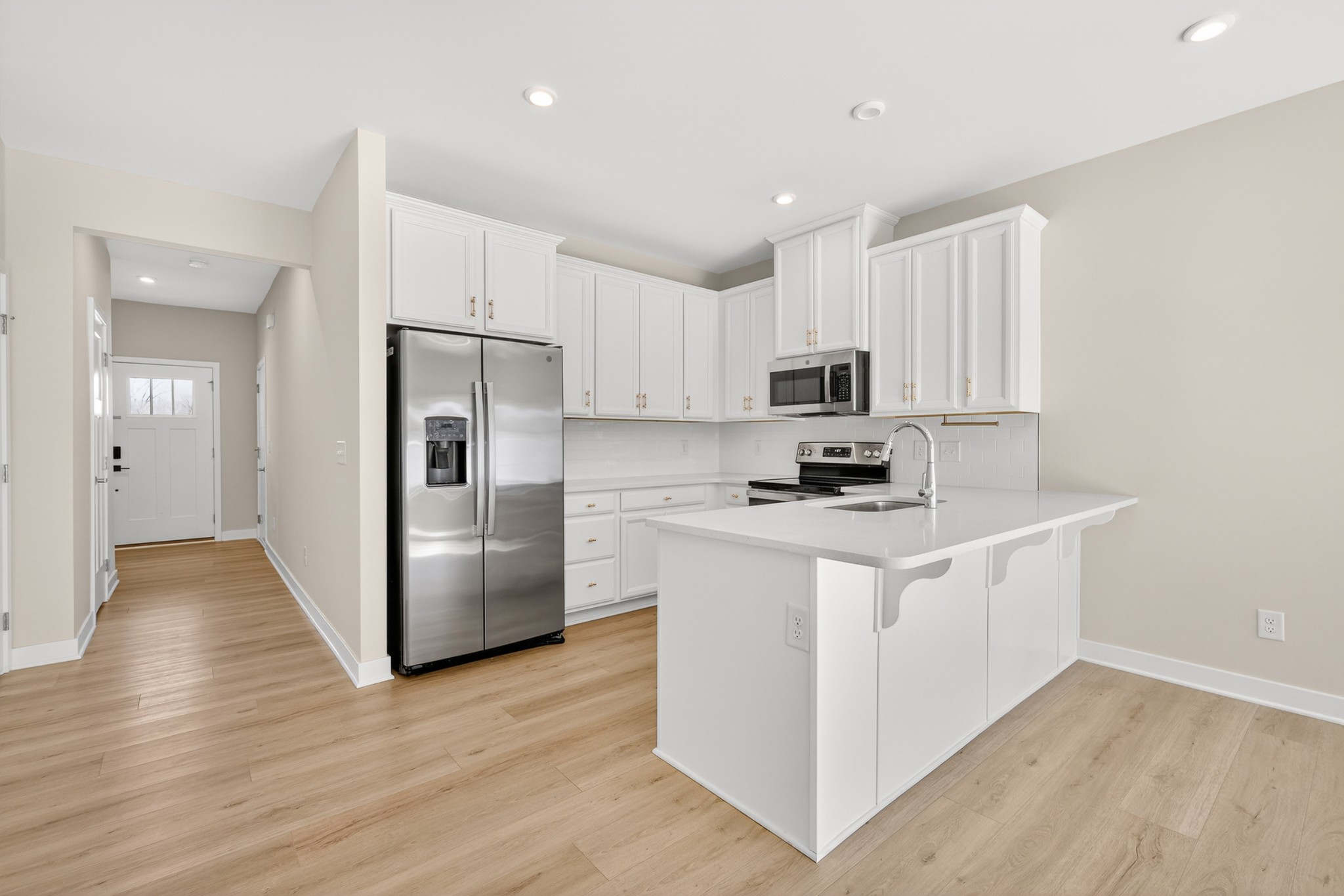 1085 Duncan Street Gallatin, TN 37066 - Photo 9 of 35 a kitchen with a refrigerator a stove top oven and wooden floor