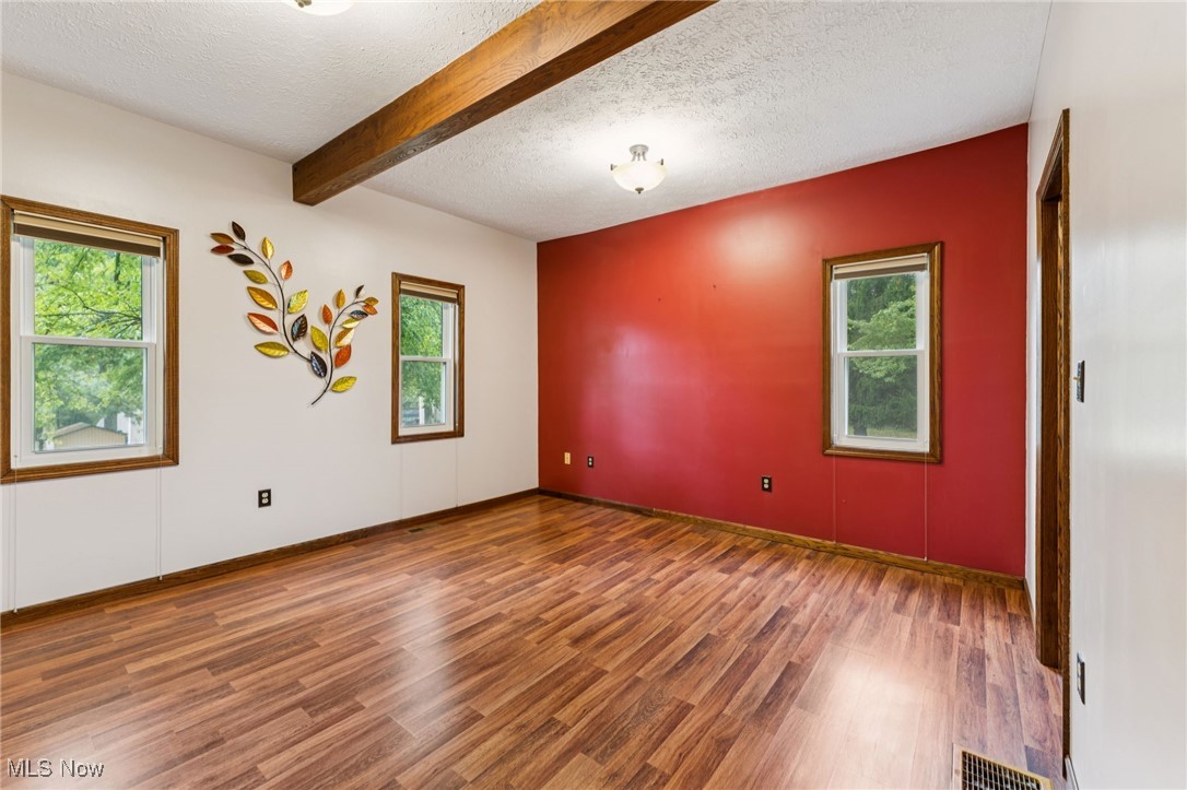 12422 Portage Street Rittman, OH 44270 - Photo 14 of 42 Spare room featuring a textured ceiling, wood finished floors, and beamed ceiling