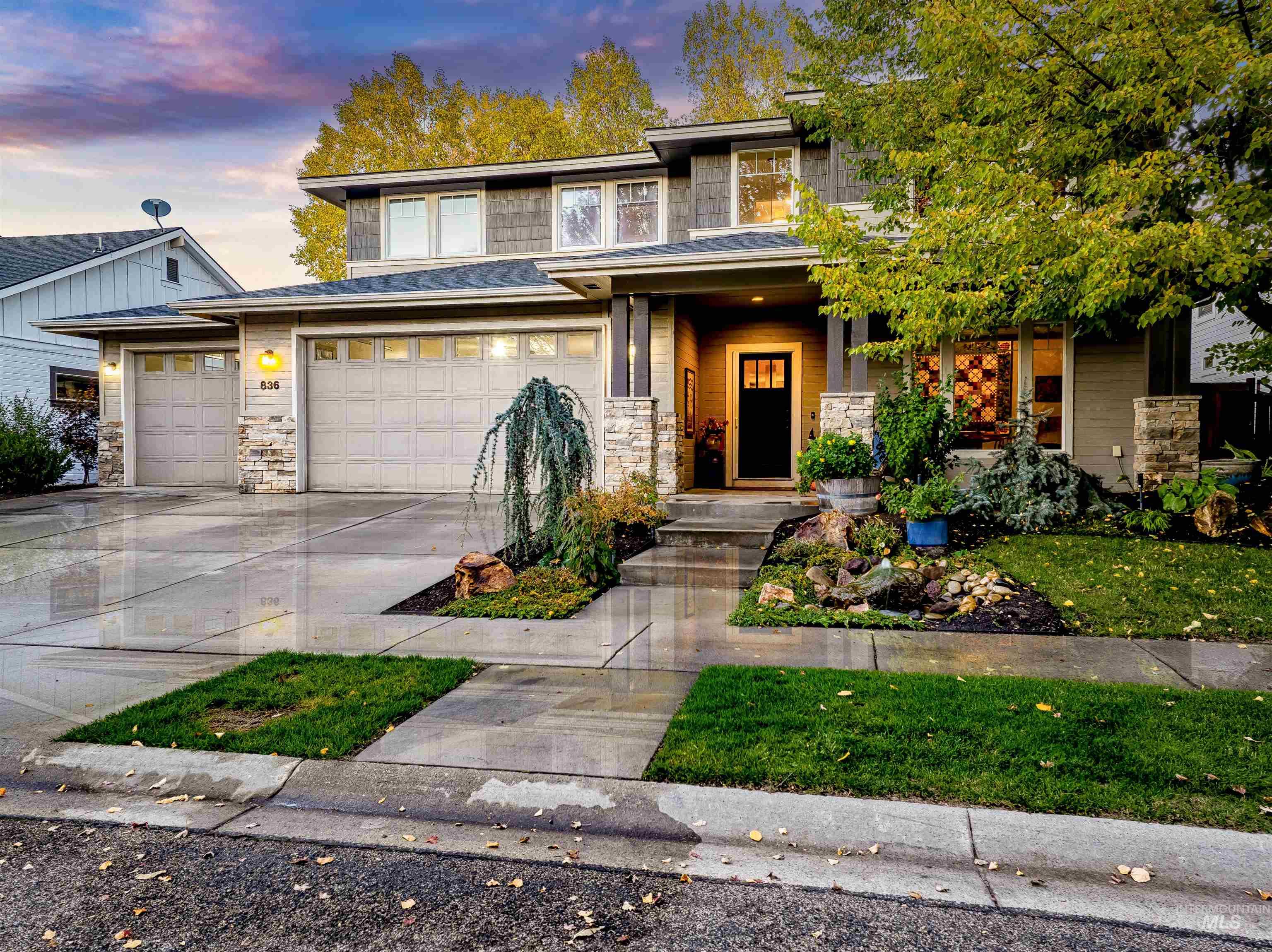 Prairie-style house with a porch, driveway, and stone siding
