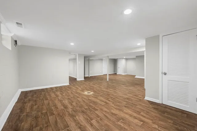 a view of empty room with wooden floor