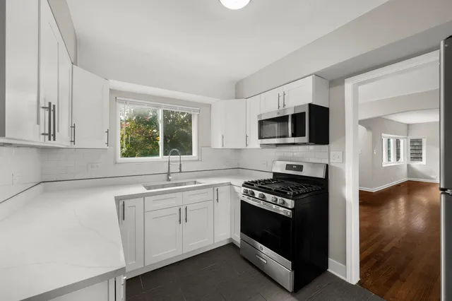 a kitchen with granite countertop a stove a sink and a microwave