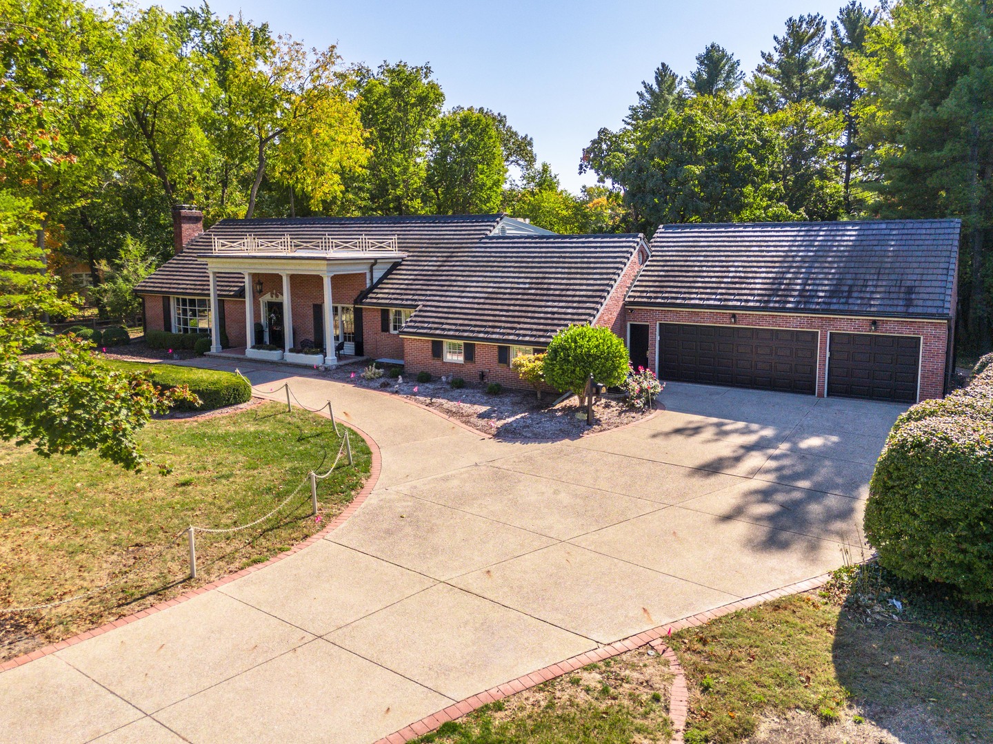 a front view of a house with a garden and trees