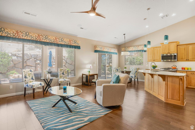 1587 Whitestone Drive St. George, UT 84790 - Photo 6 of 36 Open-concept living space featuring wood-finish flooring, vaulted ceilings, and large windows with custom valances