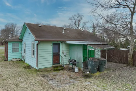 a view of a house with backyard and chairs