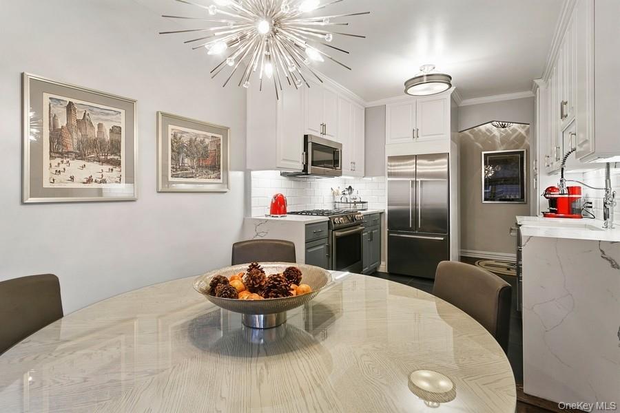 250 Bronxville Road, Unit 3I Bronxville, NY 10708 - Photo 6 of 17 a kitchen with stainless steel appliances a dining table and chairs