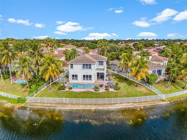 an aerial view of residential houses with outdoor space and ocean view