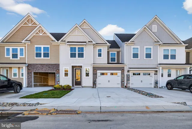 a view of a white house with a large windows next to a road