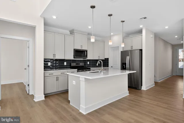 a kitchen with stainless steel appliances kitchen island a refrigerator a stove a sink and a microwave