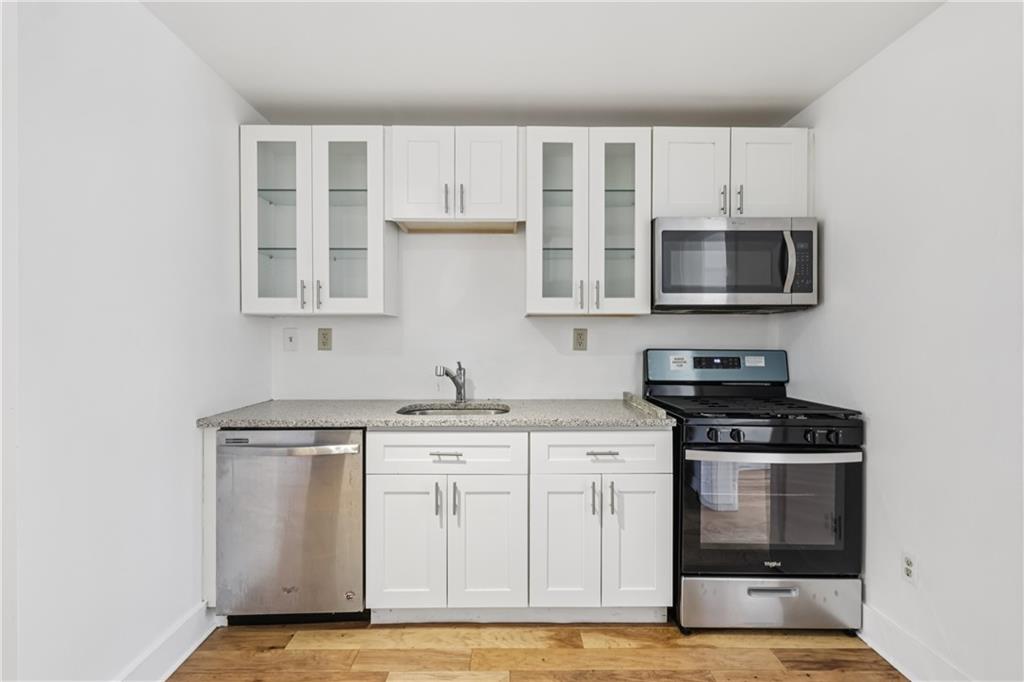 4723 Butler Street Pittsburgh, PA 15201 - Photo 17 of 47 a kitchen with stainless steel appliances a stove microwave and cabinets