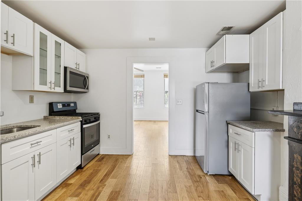 4723 Butler Street Pittsburgh, PA 15201 - Photo 18 of 47 a kitchen with stainless steel appliances a refrigerator stove microwave and sink