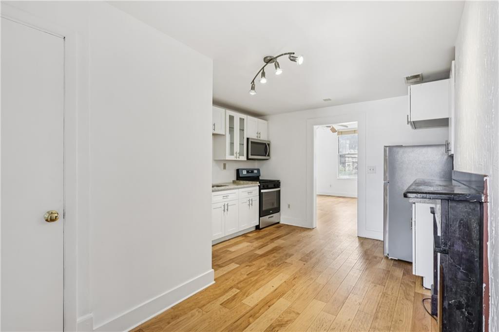 4723 Butler Street Pittsburgh, PA 15201 - Photo 19 of 47 a kitchen with stainless steel appliances granite countertop a refrigerator a stove and a sink