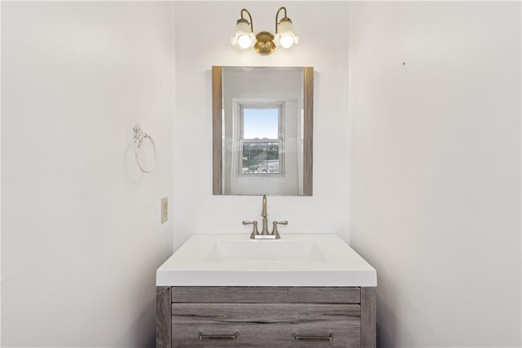4723 Butler Street Pittsburgh, PA 15201 - Photo 39 of 47 a bathroom with a sink a mirror and vanity