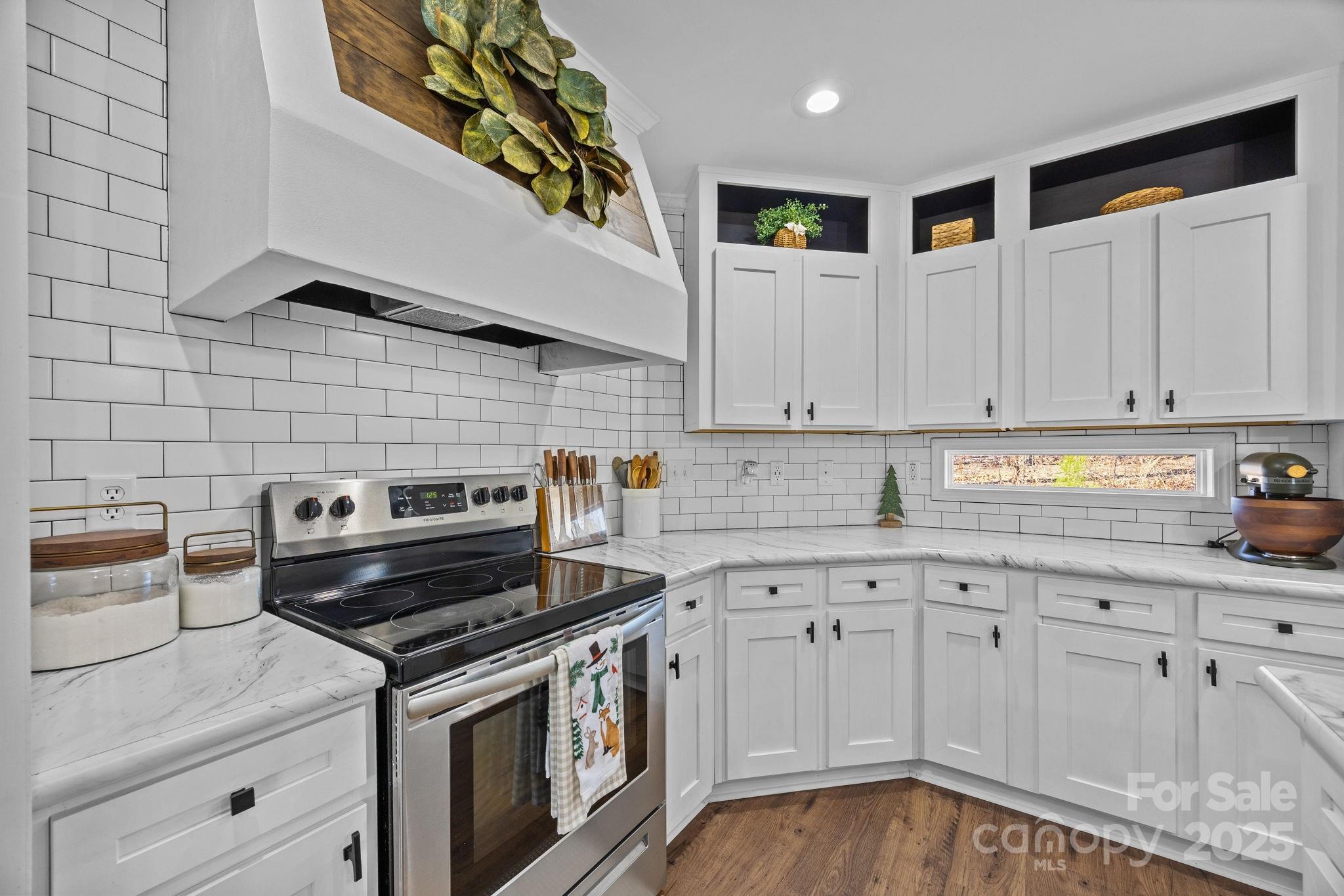 247 Aden Green Road Mill Spring, NC 28756 - Photo 20 of 48 a kitchen with white cabinets and appliances