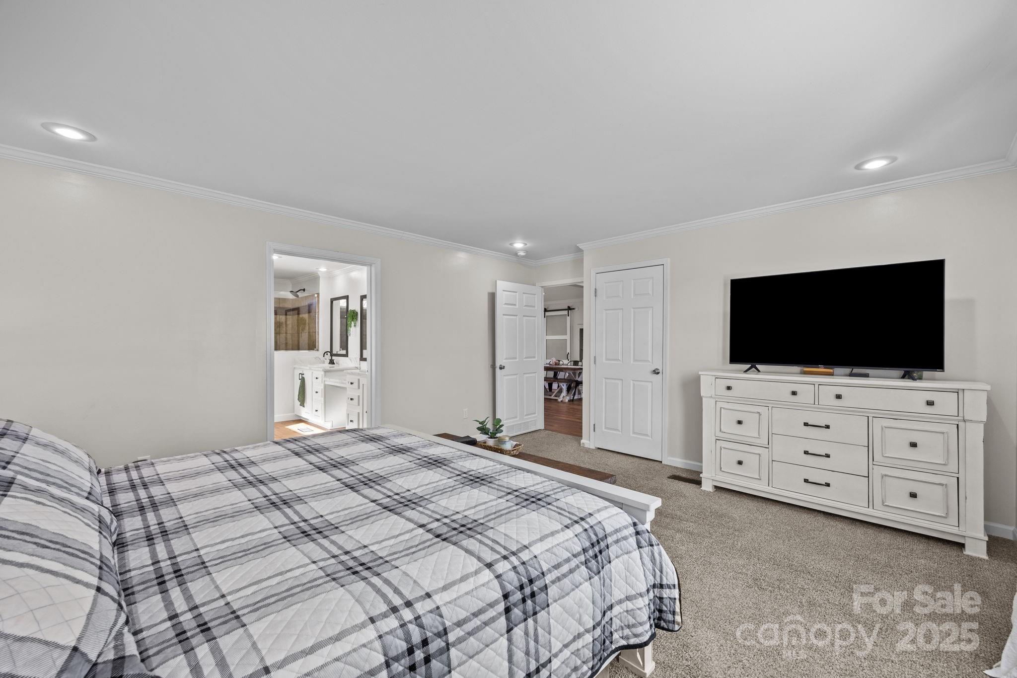 247 Aden Green Road Mill Spring, NC 28756 - Photo 23 of 48 a bedroom with a bed and a flat screen tv